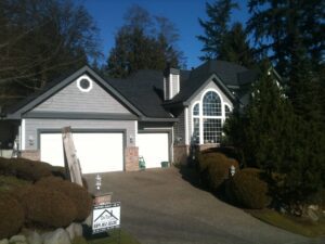 A house with two garage doors and a sign on the front.