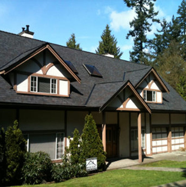 A large house with black roof and brown trim.