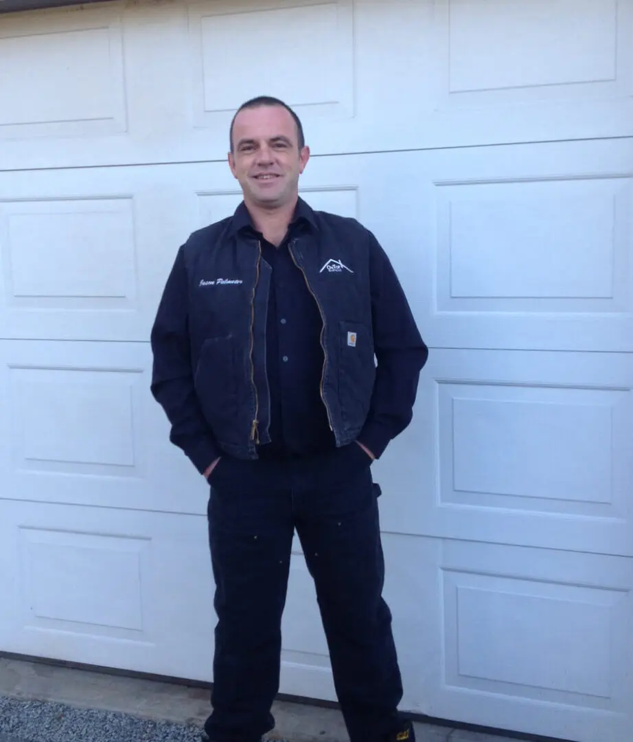 A man standing in front of a garage door.